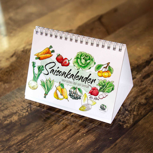 Aufstellbarer Saisonkalender mit handgezeichnetem Gemüse und Obst. Die liebevollen Aquarellillustrationen zeigen Monat für Monat, was gerade frisch verfügbar ist. Der Kalender steht stabil auf jedem Tisch oder Küchenregal. Perfekt für den bewussten Einkauf im Alltag. Nachhaltig produziert und ideal als Geschenk für Foodies und Gartenfans. Der Tischkalender ist ein wunderschöner Hingucker mit praktischem Nutzen fürs ganze Jahr und immer wieder verwendbar.